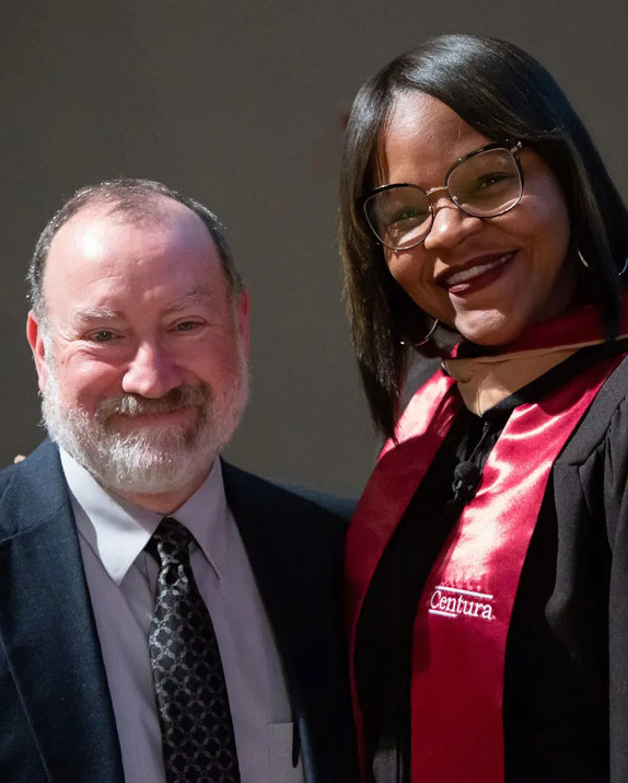 A Centura College instructor and graduate looking to the camera and smiling